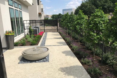 This is an example of a mid-sized modern concrete porch design in Dallas.
