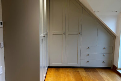 Large traditional gender neutral built-in wardrobe in Sussex with shaker cabinets and light wood cabinets.