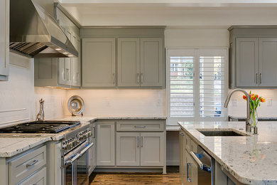 Kitchen - medium tone wood floor kitchen idea in Raleigh with an undermount sink, shaker cabinets, gray cabinets, granite countertops, white backsplash, subway tile backsplash, stainless steel appliances and an island