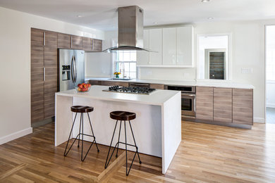 Mid-sized modern l-shaped eat-in kitchen in Richmond with an undermount sink, flat-panel cabinets, medium wood cabinets, solid surface benchtops, white splashback, stainless steel appliances, light hardwood floors and with island.