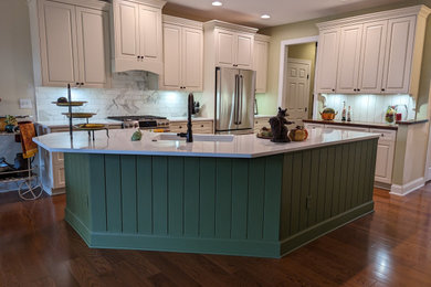 Inspiration for a mid-sized french country u-shaped medium tone wood floor and red floor eat-in kitchen remodel in Other with an undermount sink, raised-panel cabinets, green cabinets, quartzite countertops, multicolored backsplash, marble backsplash, stainless steel appliances, an island and white countertops