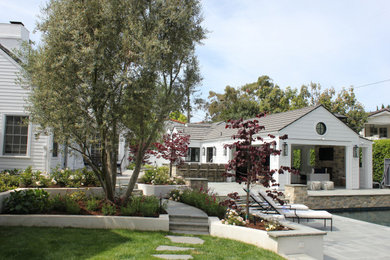 Photo of a large transitional full sun backyard retaining wall landscape in Los Angeles with decking for summer.