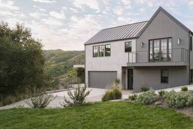 Example of a mid-sized beach style gray two-story concrete fiberboard exterior home design in Los Angeles with a metal roof and a gray roof