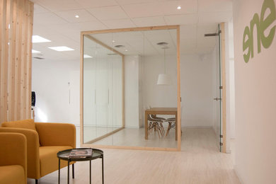 Diseño de despacho nórdico pequeño con paredes blancas, suelo laminado, escritorio independiente y suelo blanco