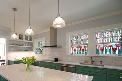 Medium tone wood floor kitchen photo in Atlanta with a single-bowl sink, shaker cabinets, green cabinets, quartz countertops, white backsplash, porcelain backsplash, stainless steel appliances, an island and white countertops