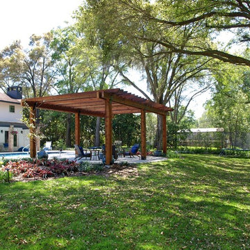 Backyard Tudor revival landscape along a natural area with a stream
