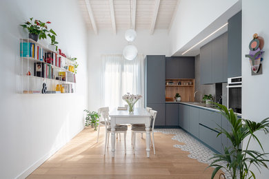 Foto di una cucina contemporanea con lavello sottopiano, ante lisce, ante grigie, parquet chiaro, pavimento beige e top grigio