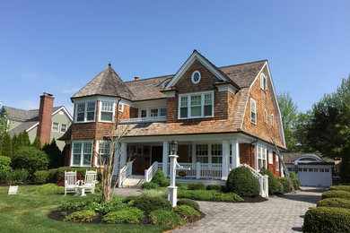 Example of a mid-sized beach style brown two-story wood house exterior design in New York with a gambrel roof and a shingle roof