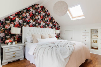 Modelo de dormitorio principal y abovedado tradicional renovado grande con paredes blancas, suelo de madera en tonos medios, suelo marrón y papel pintado