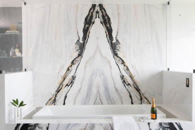 Cette image montre une grande salle de bain principale design avec un plan de toilette en marbre et meuble double vasque.
