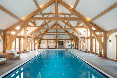 Imagen de piscina alargada clásica grande con adoquines de piedra natural