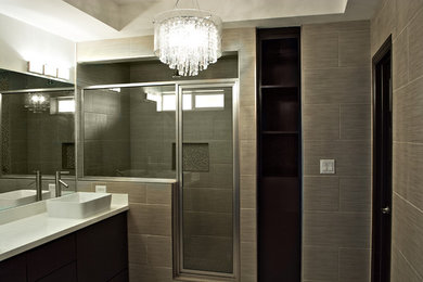 Example of a mid-sized transitional beige tile and porcelain tile porcelain tile corner shower design in Austin with a vessel sink, flat-panel cabinets, dark wood cabinets and quartzite countertops