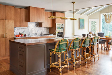 Large transitional galley medium tone wood floor and brown floor open concept kitchen photo in San Francisco with an undermount sink, marble countertops, white backsplash, marble backsplash, stainless steel appliances, an island, white countertops, flat-panel cabinets and medium tone wood cabinets