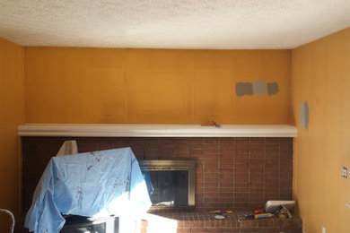 Mittelgroßes, Abgetrenntes Klassisches Wohnzimmer mit blauer Wandfarbe, Teppichboden, Kamin, Kaminumrandung aus Backstein und TV-Wand in Detroit