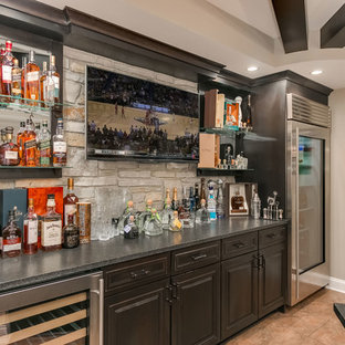Expansive traditional look-out basement in Chicago with grey walls, dark hardwood flooring, a corner fireplace, a brick fireplace surround and brown floors.