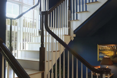 Mid-sized wood l-shaped staircase in Portland Maine with painted wood risers.