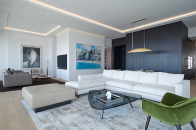 This is an example of a large modern open concept family room in Los Angeles with white walls, light hardwood floors, no tv and beige floor.