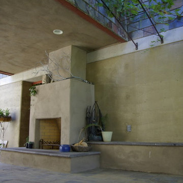 Rammed Earth Off-Grid Country Home: Outdoor fireplace under skyway