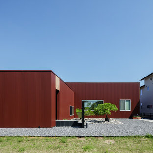 東京都下のモダンスタイルのおしゃれな家の外観 (赤い外壁、陸屋根) の写真