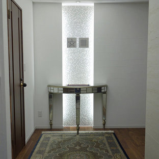 他の地域のおしゃれな玄関ホール (白い壁、合板フローリング、茶色い床) の写真