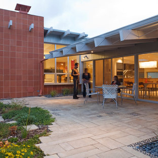 Photo of a contemporary patio in Denver with brick pavers.