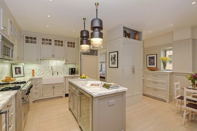 Inspiration for a transitional u-shaped light wood floor and beige floor eat-in kitchen remodel in New York with a farmhouse sink, shaker cabinets, gray cabinets, white backsplash, marble backsplash, paneled appliances, an island and marble countertops