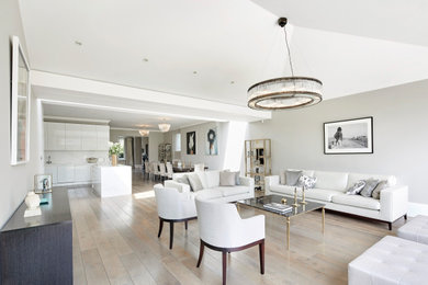 Photo of a large classic formal open plan living room in London with grey walls, light hardwood flooring, no fireplace, no tv, brown floors and a vaulted ceiling.