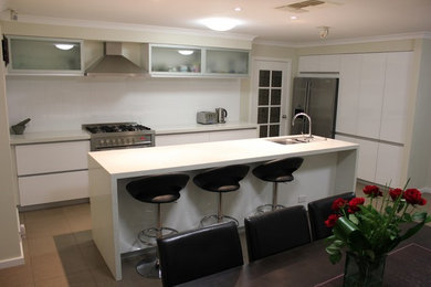 Design ideas for a mid-sized modern galley eat-in kitchen in Perth with a double-bowl sink, quartz benchtops, white splashback, cement tile splashback, stainless steel appliances, ceramic floors and with island.