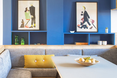 This is an example of a mid-sized contemporary open plan dining in Paris with blue walls, light hardwood floors and beige floor.