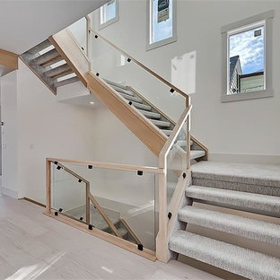 Einzeilige, Mittelgroße Moderne Küche mit Vorratsschrank, Unterbauwaschbecken, flächenbündigen Schrankfronten, schwarzen Schränken, Onyx-Arbeitsplatte, Rückwand aus Keramikfliesen, Küchengeräten aus Edelstahl, Terrazzo-Boden, Kücheninsel und weißem Boden in Calgary