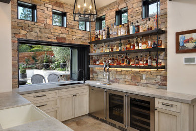 Seated home bar - mediterranean u-shaped ceramic tile and brown floor seated home bar idea in San Francisco with a drop-in sink, recessed-panel cabinets, distressed cabinets, granite countertops, multicolored backsplash, stone tile backsplash and gray countertops