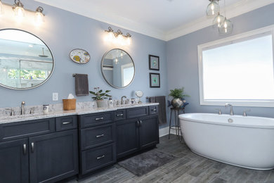 Bathroom - large transitional master white tile and porcelain tile porcelain tile, brown floor and double-sink bathroom idea in Atlanta with recessed-panel cabinets, blue cabinets, a two-piece toilet, blue walls, an undermount sink, quartz countertops, a hinged shower door, gray countertops and a built-in vanity