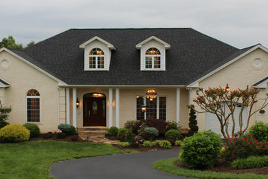 Large elegant white two-story brick house exterior photo in Other with a hip roof and a shingle roof