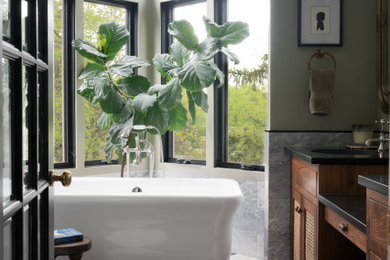 Bathroom - mid-sized transitional master green tile and marble tile marble floor, double-sink and vaulted ceiling bathroom idea in DC Metro with louvered cabinets, medium tone wood cabinets, green walls, an undermount sink, marble countertops, a hinged shower door, black countertops and a built-in vanity