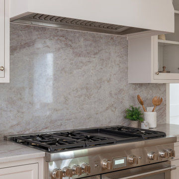 Professional gas range set against a dramatic stone slab backsplash