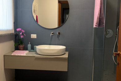 Ispirazione per una stanza da bagno con doccia minimal di medie dimensioni con ante a filo, ante beige, doccia a filo pavimento, WC monopezzo, piastrelle blu, piastrelle in gres porcellanato, pareti blu, pavimento in gres porcellanato, lavabo a bacinella, top in legno, pavimento beige, doccia aperta, top beige, un lavabo e mobile bagno sospeso