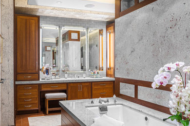 This is an example of a large contemporary master bathroom in Boston with recessed-panel cabinets, medium wood cabinets, granite benchtops, an undermount tub, an undermount sink, grey walls, medium hardwood floors and brown floor.