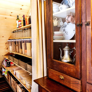 Cette image montre une arrière-cuisine chalet de taille moyenne avec un évier 2 bacs, un placard à porte plane, des portes de placard en bois clair, un plan de travail en verre, un électroménager en acier inoxydable, béton au sol, un îlot central et un sol gris.