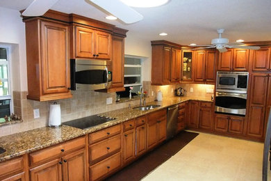 Inspiration for a large timeless kitchen remodel in Orlando with raised-panel cabinets, medium tone wood cabinets, granite countertops and no island
