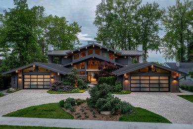 Modelo de fachada de casa multicolor y gris vintage grande de dos plantas con revestimientos combinados, tejado a dos aguas y tejado de metal