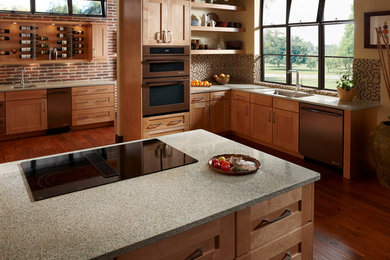 Eat-in kitchen - traditional l-shaped medium tone wood floor eat-in kitchen idea in Philadelphia with an undermount sink, medium tone wood cabinets, recycled glass countertops, shaker cabinets, white backsplash, mosaic tile backsplash, stainless steel appliances and an island