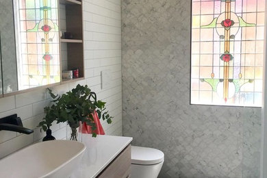 Mid-sized transitional bathroom in Melbourne with recessed-panel cabinets, medium wood cabinets, a freestanding tub, an open shower, white tile, marble, white walls, ceramic floors, a vessel sink, engineered quartz benchtops, grey floor, an open shower and white benchtops.