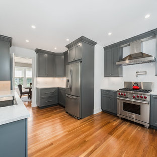 Large transitional kitchen pantry appliance - Inspiration for a large transitional l-shaped medium tone wood floor kitchen pantry remodel in Bridgeport with a double-bowl sink, flat-panel cabinets, gray cabinets, quartz countertops, white backsplash, ceramic backsplash and stainless steel appliances