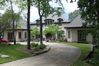 Example of a classic white two-story stucco exterior home design in Detroit