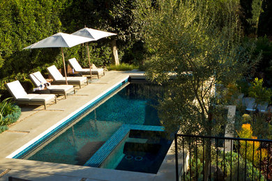 This is an example of a large contemporary drought-tolerant and full sun backyard concrete paver landscaping in Los Angeles.