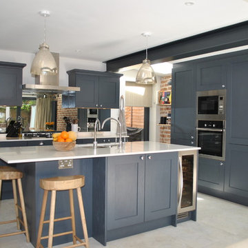Modern shaker kitchen in dark slate blue against the brick wall