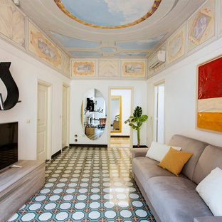 Mittelgroße, Offene Mediterrane Bibliothek mit weißer Wandfarbe, Keramikboden, freistehendem TV und buntem Boden in Florenz