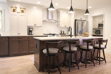 Mid-sized transitional single-wall light wood floor and brown floor eat-in kitchen photo in Detroit with an undermount sink, shaker cabinets, medium tone wood cabinets, quartz countertops, white backsplash, stainless steel appliances, an island and white countertops