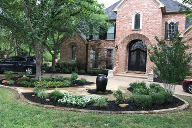 Inspiration for a mid-sized traditional partial sun front yard stone water fountain landscape in Dallas.