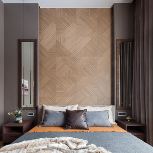 Inspiration pour une chambre parentale design de taille moyenne avec un mur gris, un sol en bois brun et un sol jaune.